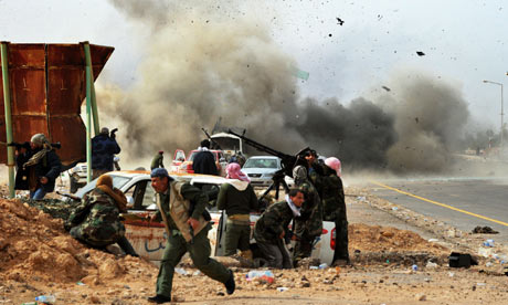 A tank shell explodes near Libyan rebel fighters outside Ras Lanuf. Roberto Schmidt/AFP/Getty Images