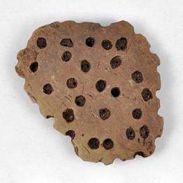 A fragment of a sieve that researchers say were used as cheese strainers.