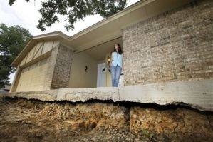 Barbara Brown poses for a photo on the front step of her home that now sits about one foot off the surface of her lawn, Saturday, June 21, 2014, in Reno, Texas.