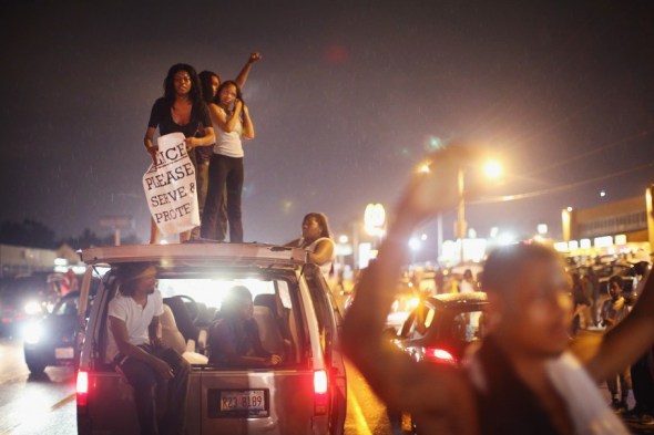 Demonstrators gather along West Florissant Avenue on Friday to protest the shooting of Michael Brown in Ferguson, Mo. Brown was shot and killed by a Ferguson police officer on Aug. 9. Friday’s demonstration ended with protesters clashing with police followed by more looting. (Scott Olson/Getty Images)