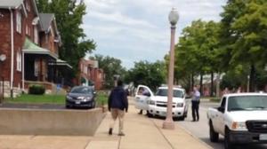 A man identified as Kajiene Powell, with an object in his right hand, approaches police in north St. Louis. Police say that the object was a knife and that he threatened officers before he was shot to death. (St. Louis Police Department)