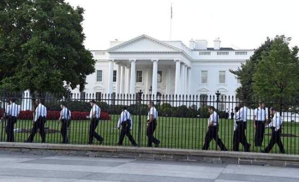 Uniformed Secret Service officers walk along the fence on the north side of the White House on Sept. 20 in Washington. (Susan Walsh / AP)