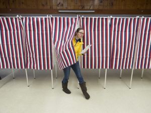 woman exists voting booth, Laonia, NH