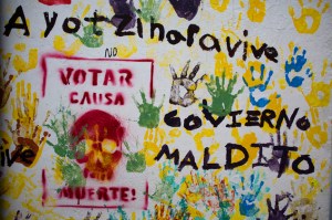 Graffiti in the central square of Tixtla, home of the rural normal school at Ayotzinapa, reads "Ayotzinapa lives. Voting causes death. Cursed government," in Tixtla, Mexico, Saturday, June 6, 2015. (AP Photo/Rebecca Blackwell)