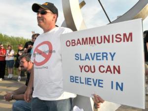 By Jamie Lynn Chevillet /Journal & Courier-- Joe Daubenmier holds a sign giving his opinion at Tea Party 3 hosted by the group Citizens in Action held on the John T. Myers Pedestrian Bridge in Lafayette on Thursday, April 15, 2010.