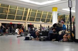 Passengers huddled near the ground at immigration control while police looked for a possible shooter at JFK airport. It turned out to be a false alarm. PHOTO: BRIGITTE DUSSEAU/AGENCE FRANCE-PRESSE/GETTY IMAGES