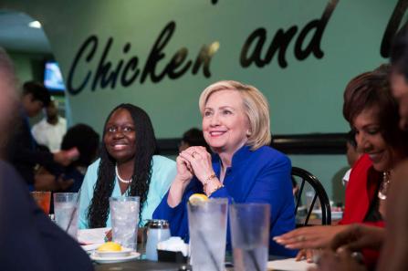 Democratic presidential candidate Hillary Clinton talks with people assembled to meet her while sitting with business leaders Kiki Smith Cyrus (L) and Cynthia Hardy (R) at Kiki's Chicken and Waffles restaurant in Columbia, South Carolina May 27, 2015. REUTERS/Chris Aluka Berry - RTX1ET8O
