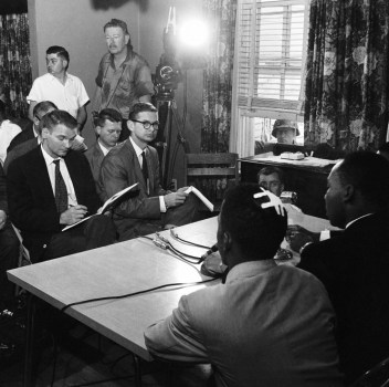 John Lewis, with bandaged head sits next to MLK during press briefing.