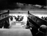 While under attack from heavy machine gun fire from the German coastal defense forces, American soldiers wade ashore off the ramp of a U.S. Coast Guard landing&nbsp;craft.