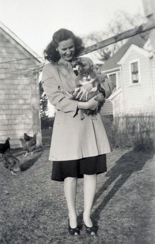 Woman holding cat, 1940s